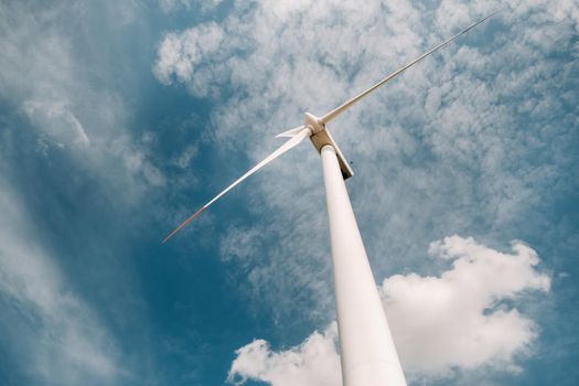 A white Windmill against a blue sky. Windmill in nature.