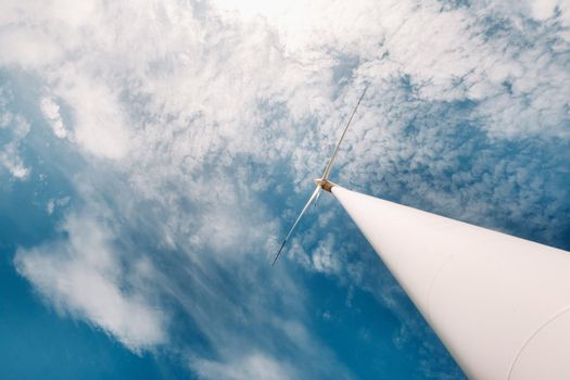 A white Windmill against a blue sky. Windmill in nature.