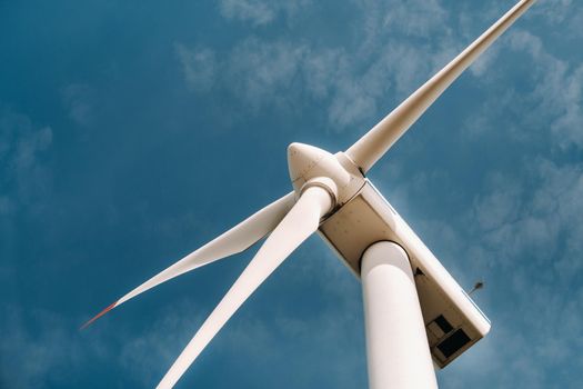 A white Windmill against a blue sky. Windmill in nature.