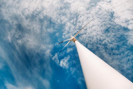 A white Windmill against a blue sky. Windmill in nature.