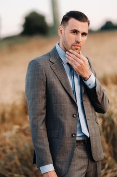 Portrait of a businessman in a gray suit in a wheat field.A man in nature in a jacket and tie.