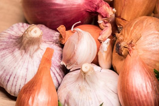 garlic onion shallot parsley on a wooden board