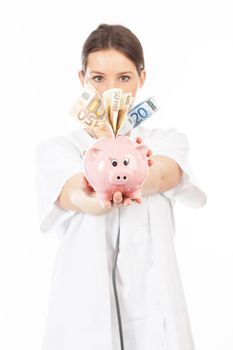 A woman shows a piggy bank full of European banknotes