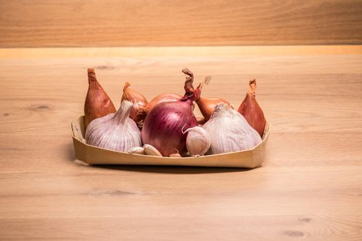 garlic onion shallots in a small wooden basket