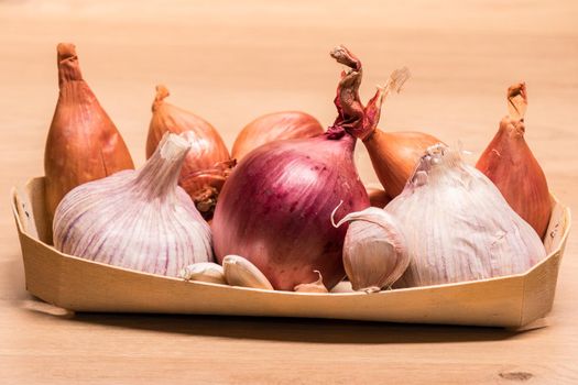 garlic onion shallots in a small wooden basket