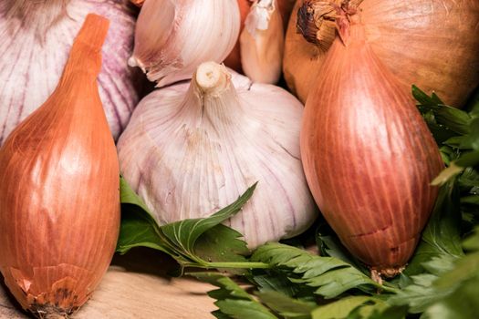 garlic onion shallot parsley on a wooden board