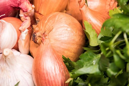 garlic onion shallot parsley on a wooden board