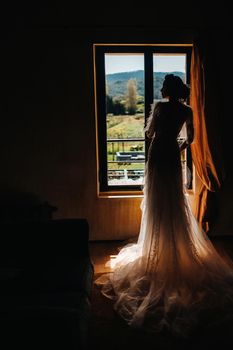 pretty blonde bride with nicea beautiful bride with pleasant features in a wedding dress poses in the interior of the room. Portrait of the bride in Provence. France.