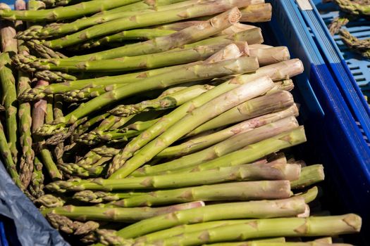 crate of fresh green asparagus on a market