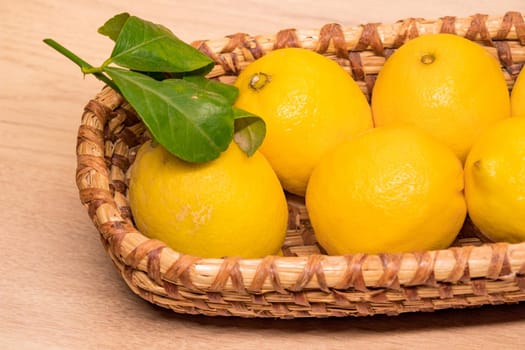 yellow lemons in a small wooden basket