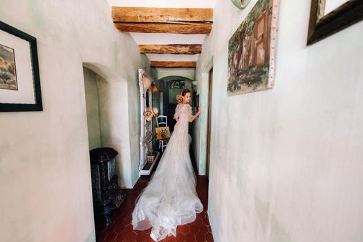 pretty blonde bride with nicea beautiful bride with pleasant features in a wedding dress poses in the interior of the room. Portrait of the bride in Provence. France.