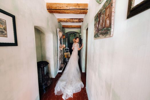 pretty blonde bride with nicea beautiful bride with pleasant features in a wedding dress poses in the interior of the room. Portrait of the bride in Provence. France.