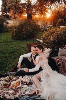 Dinner the Bridal couple at the picnic.A couple is relaxing at sunset in France.Bride and groom on a picnic in Provence