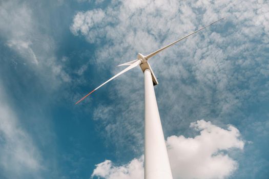 A white Windmill against a blue sky. Windmill in nature.