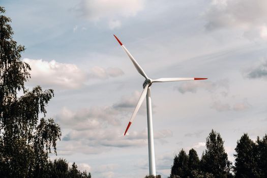 A white Windmill against a blue sky. Windmill in nature.