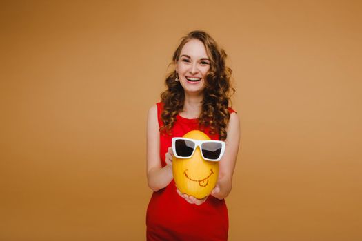 Portrait of a happy young woman holding a melon with glasses. Melon with a smile.