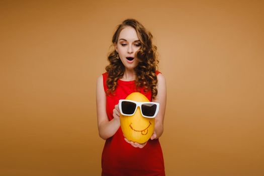 Portrait of a happy young woman holding a melon with glasses. Melon with a smile.