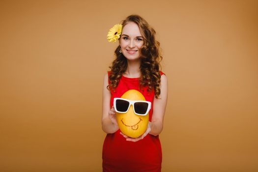 Portrait of a happy young woman holding a melon with glasses. Melon with a smile.