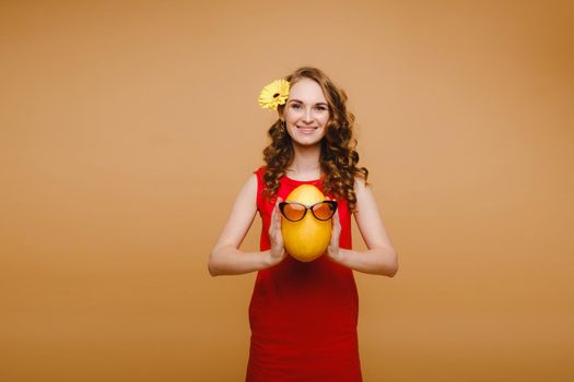 Portrait of a happy young woman holding a melon with glasses. Melon with a smile.