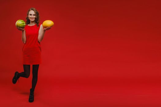 Photo of wavy cheerful curly casual positive cute nice charming pretty girlfriend smiling toothily having fetched you a watermelon isolated over vivid orange color background.