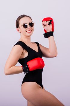 Studio portrait of a boxer female in bodysuit with gloves red