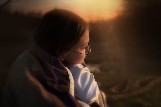 The family, mother and daughter, for the weekend went out into the countryside for a picnic, sit by the fire in the wild with a tent, fry potatoes, drink hot tea. High quality photo