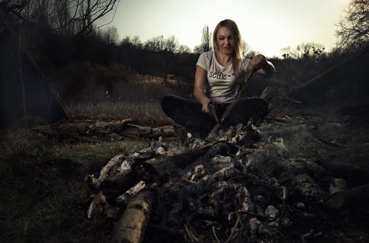  A girl cuts wood for a fire at a picnic. High quality photo