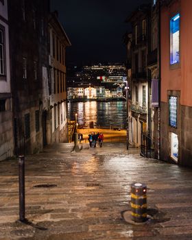 Historic old street of oporto city with douro river in the background.