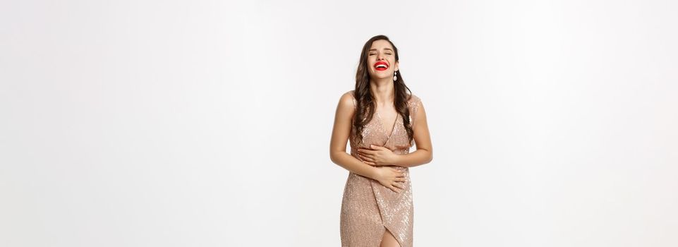 Party and celebration concept. Full-length of elegant woman with red lips, standing near Christmas gifts and laughing happy, standing over white background.