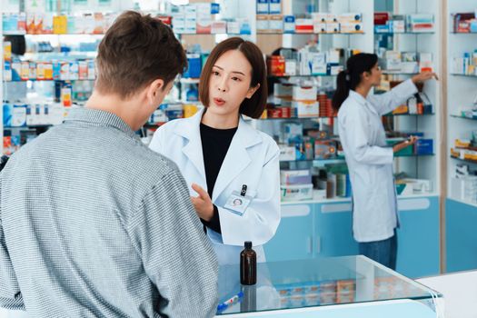 Professional pharmacist advise or explain property of qualified medical product to customer in pharmacy, druggist answer to client healthcare inquiry, medical service and consultation concept.