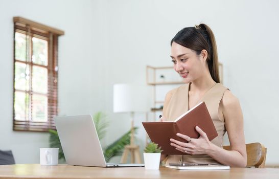 Asian businesswoman meeting at the office, taking notes and using a tablet at the office...