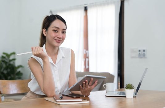 Portrait of Young woman using laptop computer at the office, Student girl working at home. Work or study from home, Asian woman freelance, business, lifestyle concept..