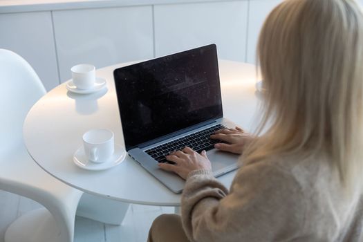 young woman working from home using computer, at home workplace using technology