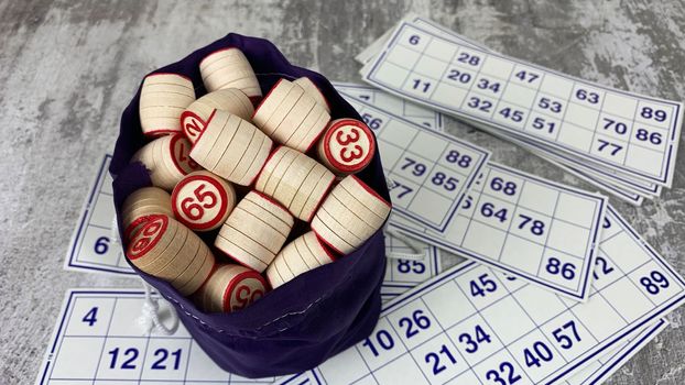 Loto game on the table. Wooden barrels for a board game with family and friends