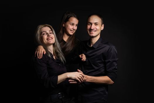 happy family mother, father, daughter on a black background.