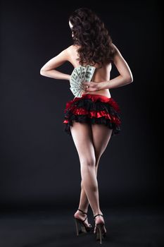 Image of topless flamenco dancer with dollars, on black background