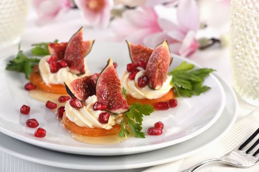 Roasted sweet potato rounds as a vegetarian snack. Perfect for a festive feast, they are topped with creamy whipped yogurt feta, juicy figs and honey and pomegranate. Vegetarian Gluten Free