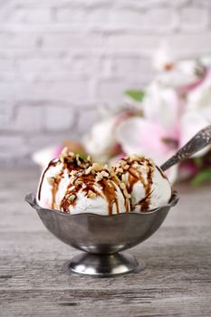 Summer cold dessert - three balls plombir ice cream   with chocolate sauce, crushed peanut nuts 