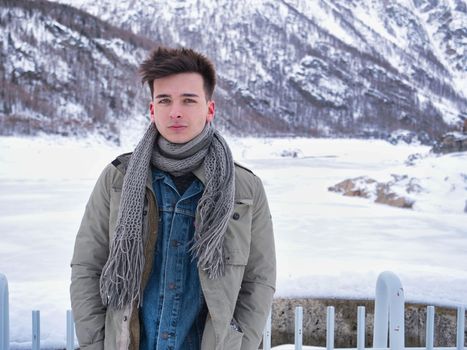 Young attractive man in the mountain in winter with snow around him