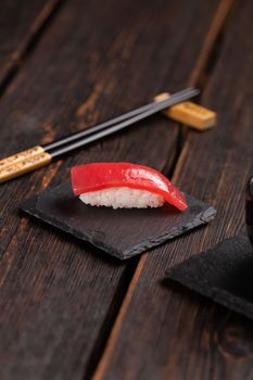 Delicious sushi maguro tuna. Nigiri with tuna black and wooden background . Traditional Japanese cuisine