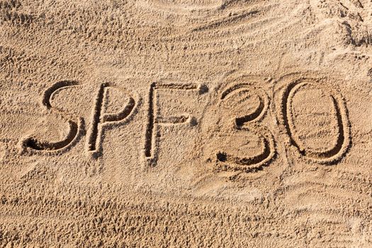 Sun protect factor thirty concept. SPF 30 word written on the beach.