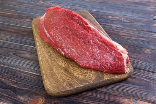 red fresh raw beef veal fillet on cutting board. Black wooden background.