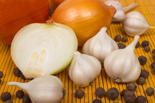 Garlic and onion, pepper on wooden board.