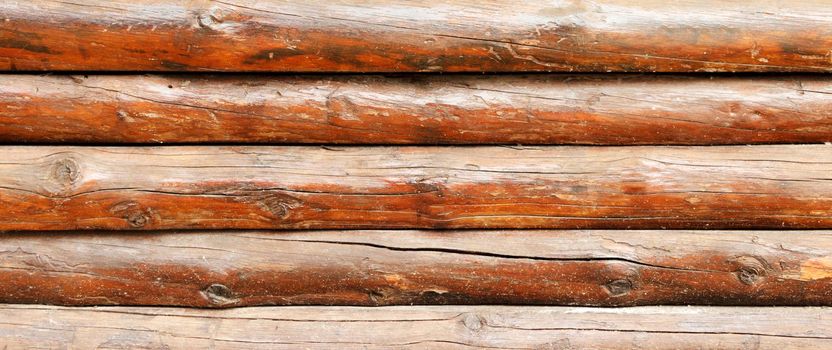 wall made of wooden logs background. wooden beams fence texture .