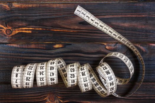 Tailoring Meter White measuring tape on wooden background.