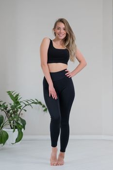 Full length portrait of a beautiful caucasian woman in black sportswear