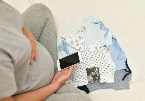 Pregnant woman takes pictures of ultrasound image of her baby