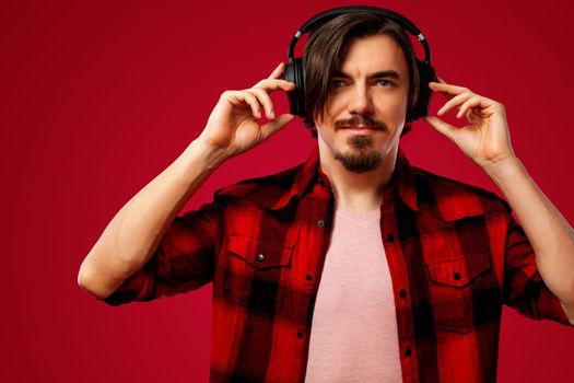 Handsome european man in yellow outfit smiling and dancing in excellent mood on blue background. Slow motion.