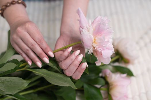 girl's hands with a beautiful pink manicure design, pastel color, gently, flowers in spring. High quality photo