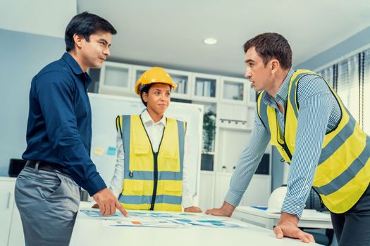 A group of competent engineers and employer discuss plans in the office. Architectural investor, businessman, and engineer discussing blueprints.